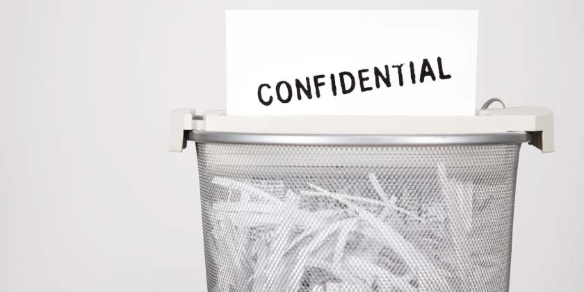 A shredder shredding a confidential letter A shredder shredding a confidential letter