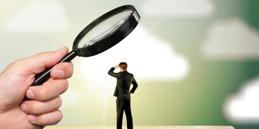 A man in a business suit under a magnifying glass