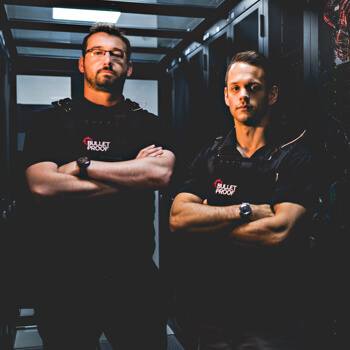 2 men in Bulletproof vests standing in a server room 2 Bulletproof data protection officers