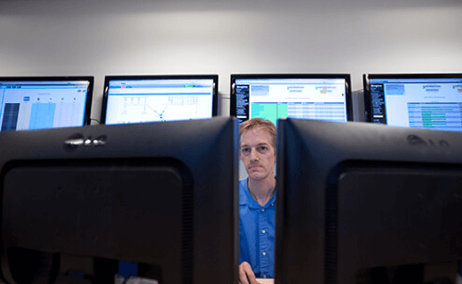 An employee working in front of monitoring screens