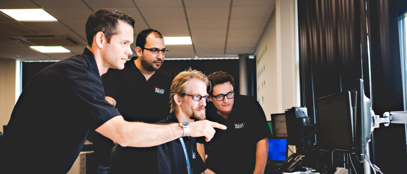 Bulletproof engineers looking at a computer