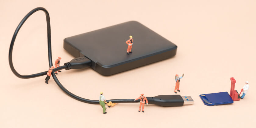 A USB hard rive with small figurines trying to connect it