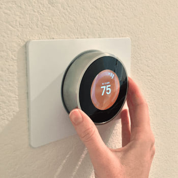A smart thermostat A changing the temperature on a digital thermostat