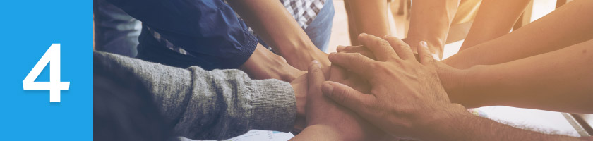 A group putting their hands in the middle together next to a number 4