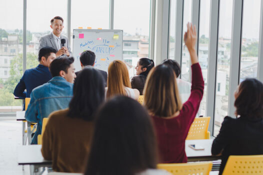 Women putting hand up in meeting