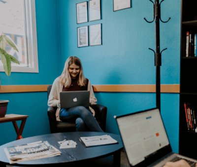 A woman sitting on a chair with a laptop